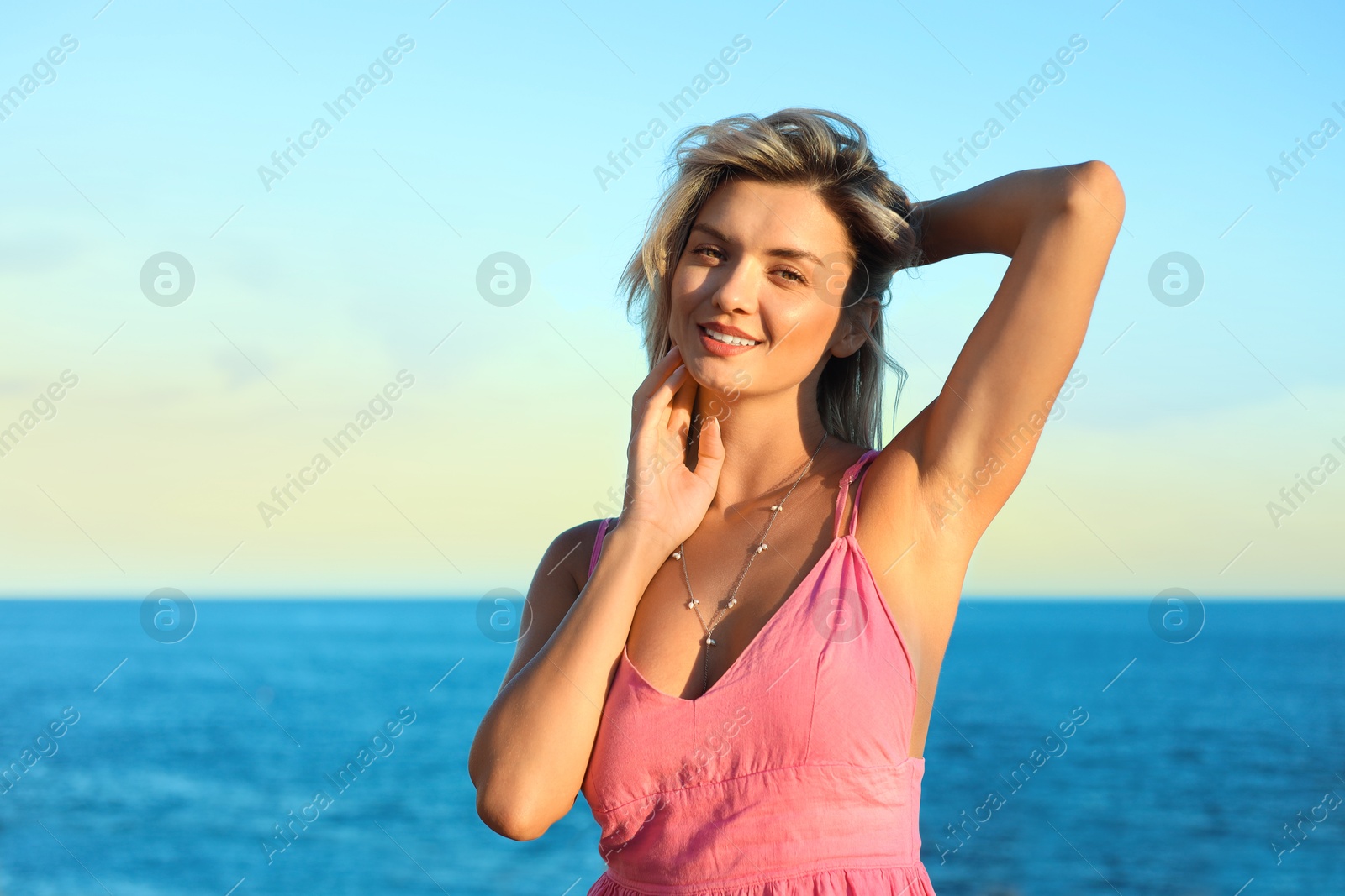 Photo of Happy woman near sea on summer day, space for text