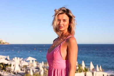 Photo of Portrait of beautiful woman near sea on sunny day