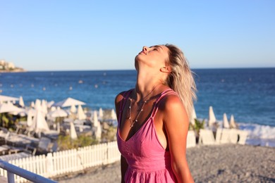 Photo of Portrait of beautiful woman near sea on sunny day