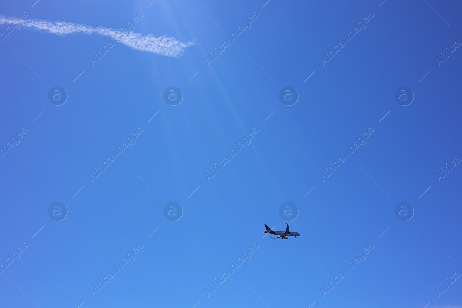 Photo of Airplane flying in beautiful blue sky, bottom view