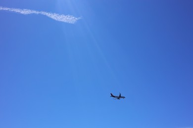 Photo of Airplane flying in beautiful blue sky, bottom view