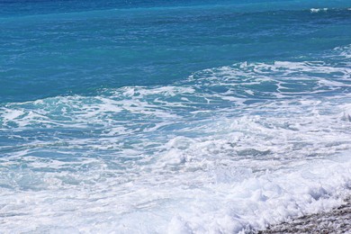 Photo of Beautiful view of wavy sea, city and pebbles on beach