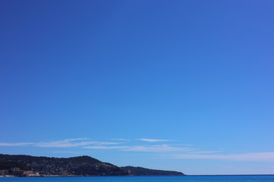 Photo of Beautiful view of wavy sea and mountains under blue sky