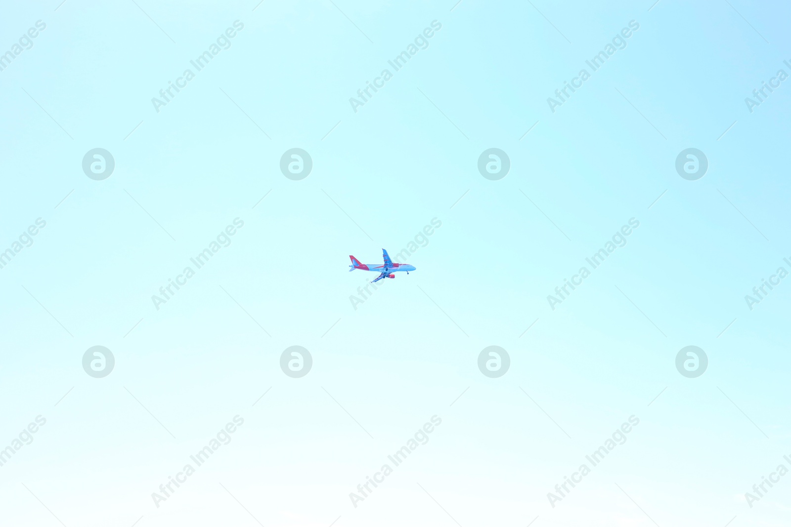 Photo of Airplane flying in beautiful blue sky, bottom view