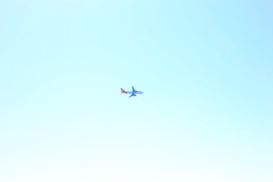 Photo of Airplane flying in beautiful blue sky, bottom view