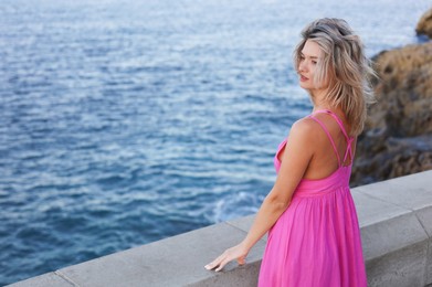Photo of Beautiful woman near sea on summer day, space for text