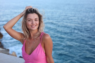 Photo of Beautiful woman near sea on summer day, space for text