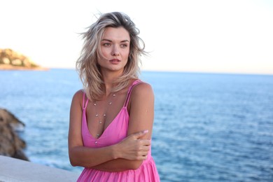 Photo of Beautiful woman near sea on summer day, space for text