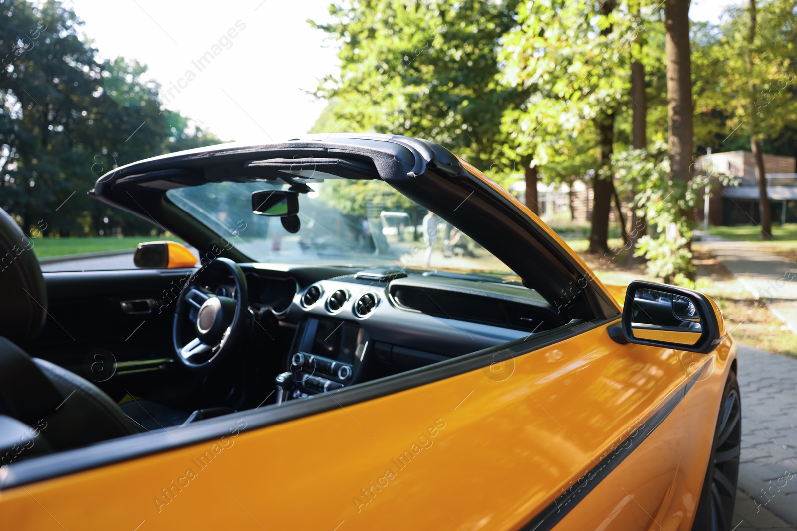 Photo of Modern cabriolet parked on parking lot outdoors, closeup