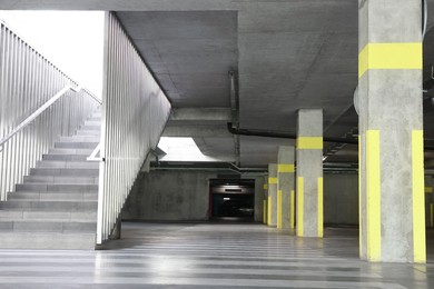 Photo of View of empty underground parking with dedicated spots, pedestrian crossing and stairs