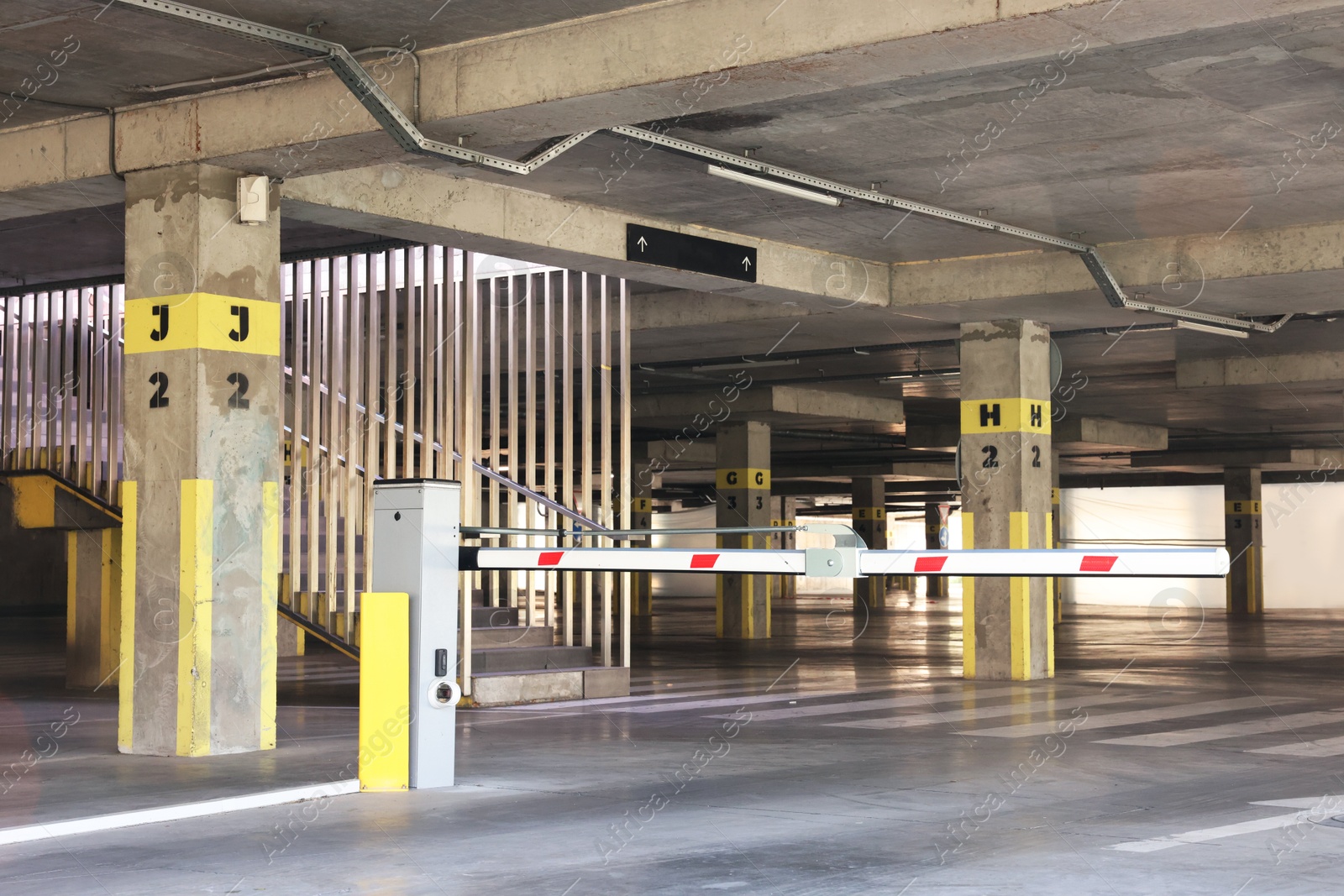 Photo of Underground parking with bar gate, dedicated spots, pedestrian crossing and stairs