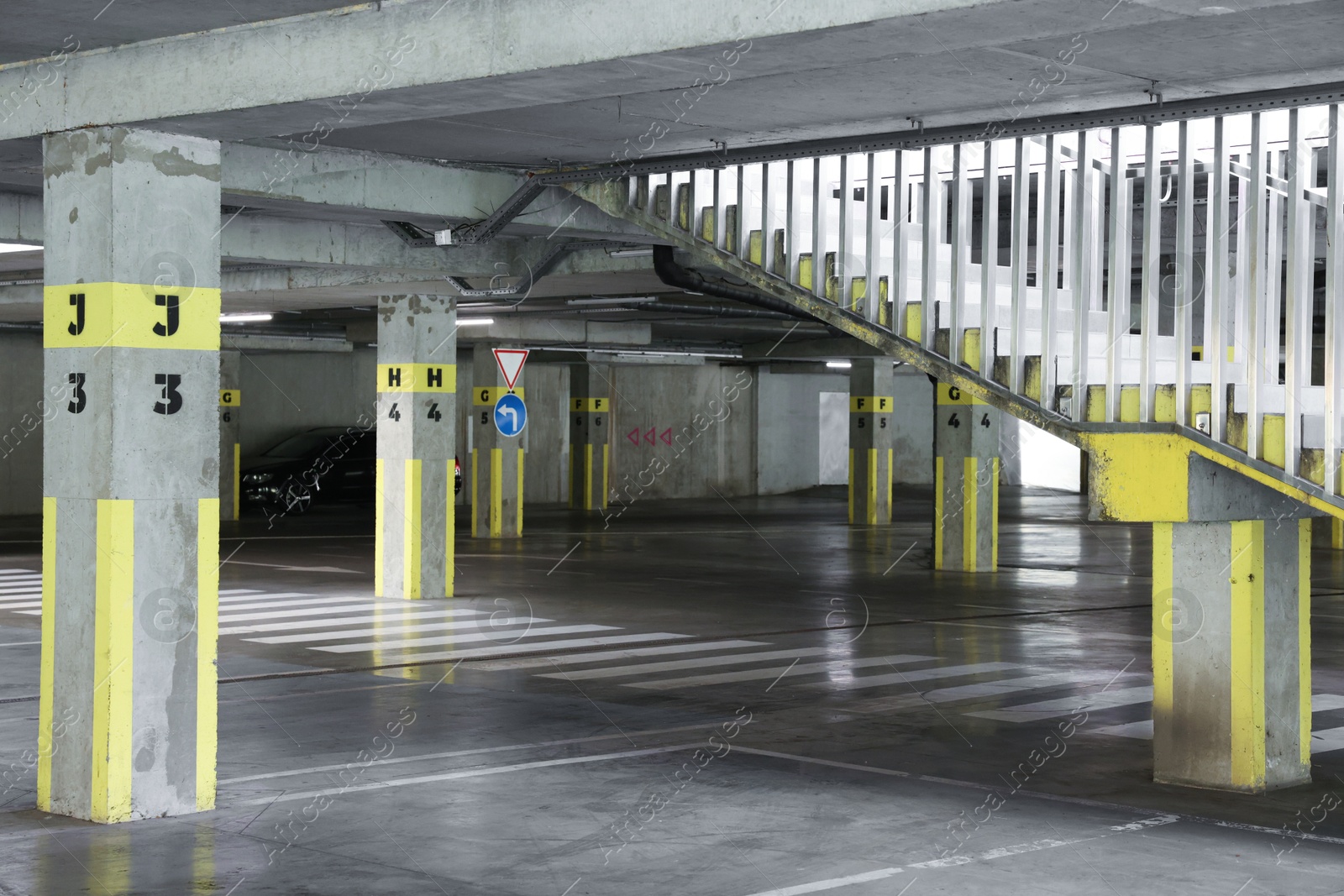 Photo of Underground parking with dedicated spots, pedestrian crossing, stairs and car