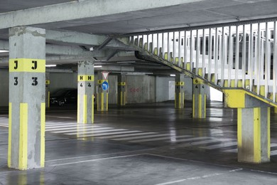 Photo of Underground parking with dedicated spots, pedestrian crossing, stairs and car