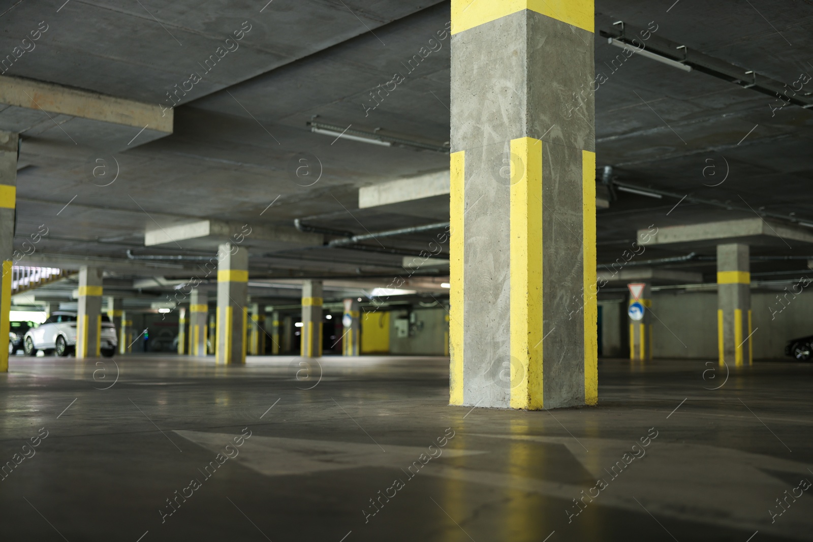 Photo of Underground parking with dedicated spots and cars, low angle view