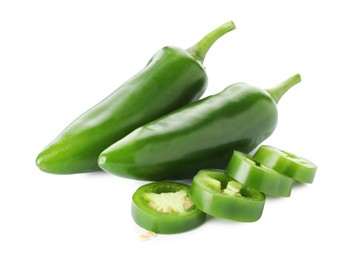 Photo of Whole and sliced green jalapeno peppers isolated on white