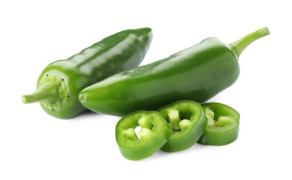 Photo of Whole and sliced green jalapeno peppers isolated on white