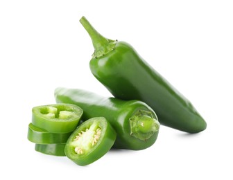 Photo of Whole and sliced green jalapeno peppers isolated on white