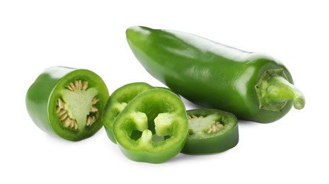 Photo of Whole and sliced green jalapeno peppers isolated on white