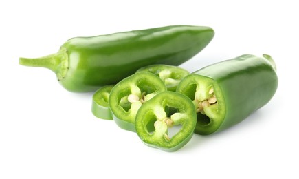 Photo of Whole and sliced green jalapeno peppers isolated on white