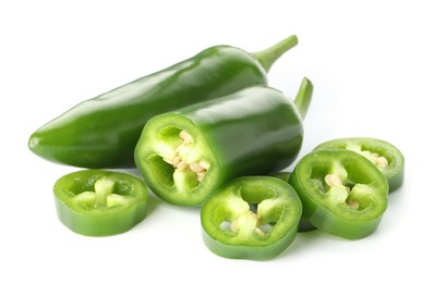 Photo of Whole and sliced green jalapeno peppers isolated on white