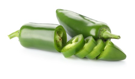 Photo of Whole and sliced green jalapeno peppers isolated on white