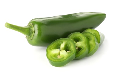 Photo of Whole and sliced green jalapeno peppers isolated on white