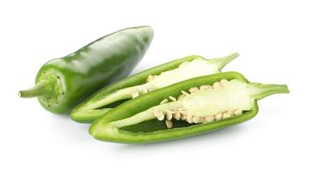 Photo of Whole and cut green jalapeno peppers isolated on white