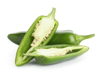Photo of Whole and cut green jalapeno peppers isolated on white