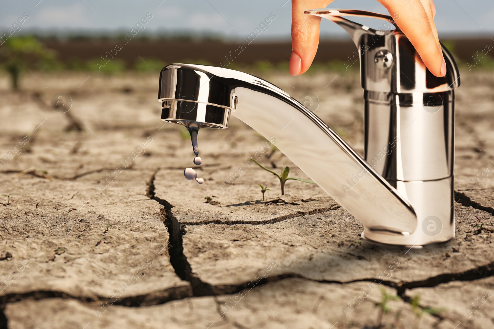 Image of Save water concept. Woman turning on or off tap on cracked ground, closeup