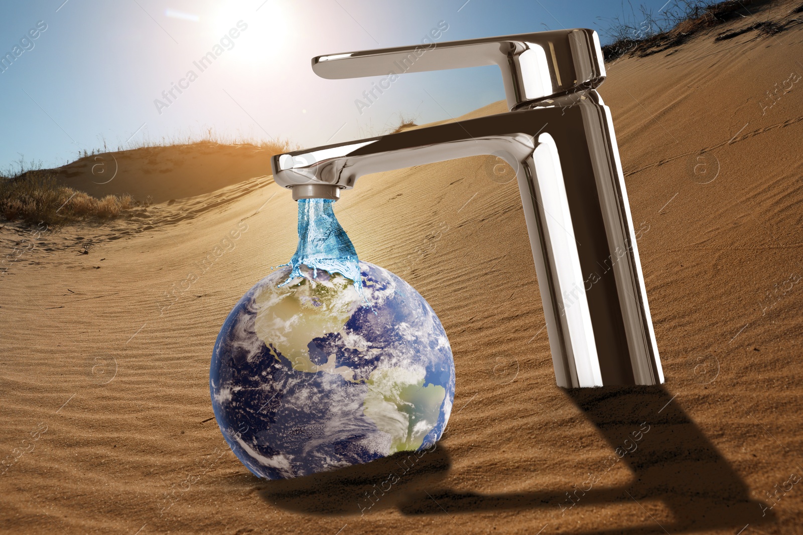 Image of Save water concept. Earth under flow of water from tap in desert