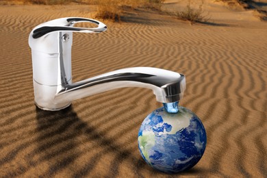 Image of Save water concept. Earth under tap with dripping water in desert