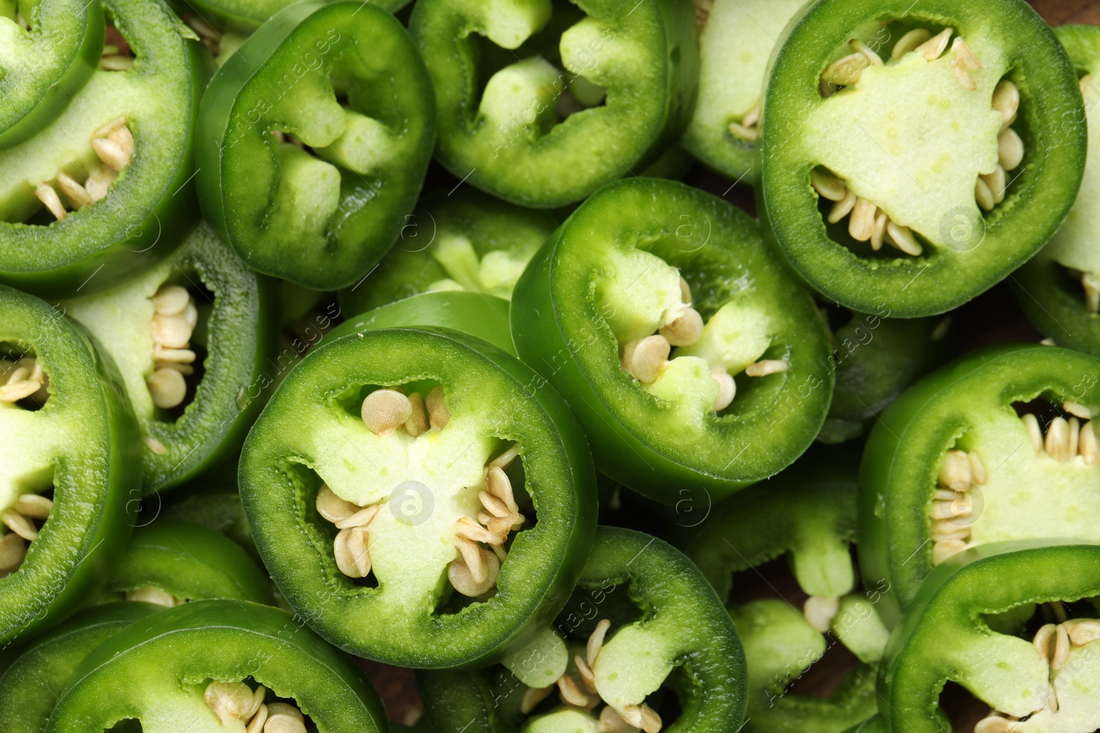 Photo of Fresh green jalapeno pepper slices as background, closeup