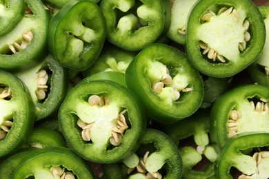 Photo of Fresh green jalapeno pepper slices as background, closeup