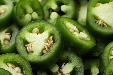 Photo of Fresh green jalapeno pepper slices as background, closeup