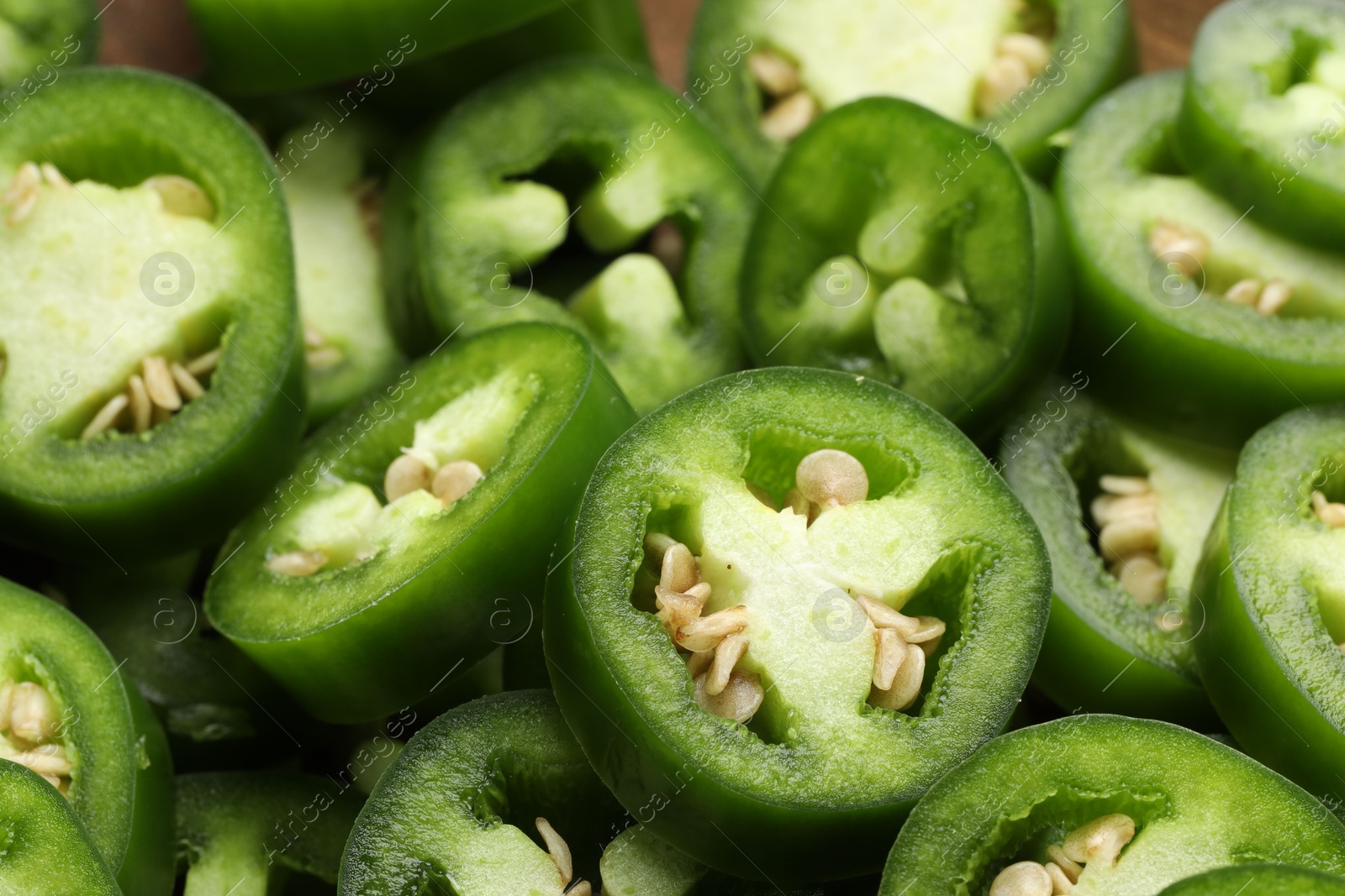 Photo of Fresh green jalapeno pepper slices as background, closeup