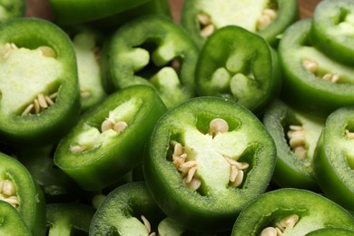 Photo of Fresh green jalapeno pepper slices as background, closeup