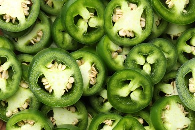 Photo of Fresh green jalapeno pepper slices as background, top view