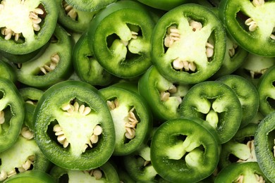 Photo of Fresh green jalapeno pepper slices as background, top view