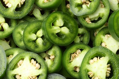 Photo of Fresh green jalapeno pepper slices as background, top view