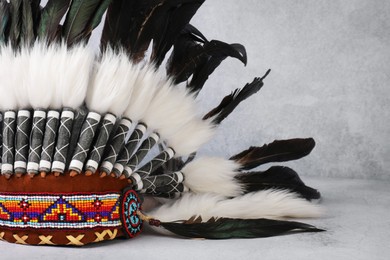 Photo of Traditional warbonnet (Native American chief headdress) on light grey table, closeup