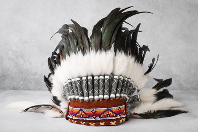 Photo of Traditional warbonnet (Native American chief headdress) on light grey table