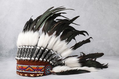 Photo of Traditional warbonnet (Native American chief headdress) on light grey table