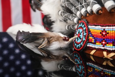 Photo of Traditional warbonnet (Native American chief headdress) on black mirror surface, closeup