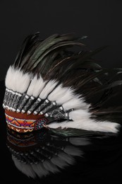 Photo of Traditional warbonnet (Native American chief headdress) on black mirror surface