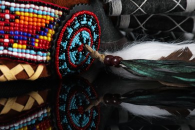 Photo of Traditional warbonnet (Native American chief headdress) on black mirror surface, closeup