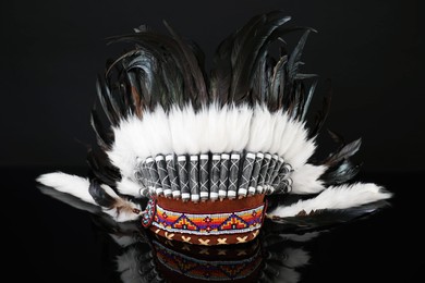 Photo of Traditional warbonnet (Native American chief headdress) on black mirror surface