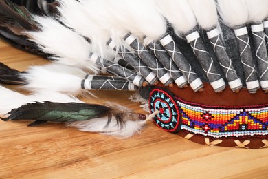 Photo of Traditional warbonnet (Native American chief headdress) on wooden table, closeup