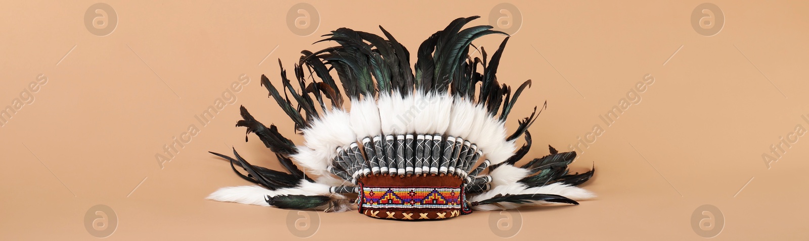 Photo of Traditional warbonnet (Native American chief headdress) on beige background