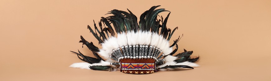 Photo of Traditional warbonnet (Native American chief headdress) on beige background