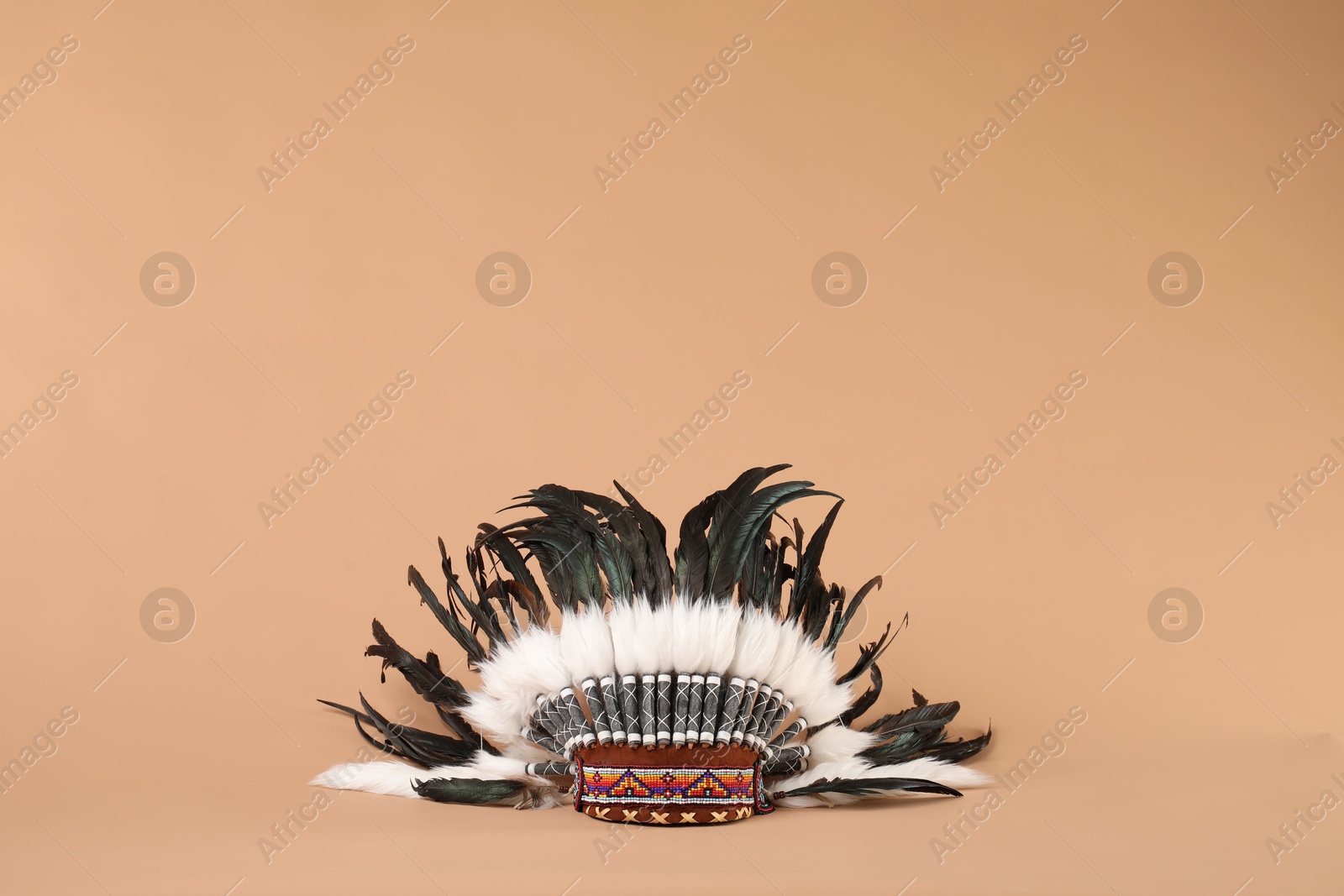 Photo of Traditional warbonnet (Native American chief headdress) on beige background